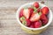 Fresh strawberries in a bowl on wooden table,Red strawberry prepatation to make Strawberry Juice.Healthy and delicious organic