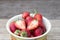 Fresh strawberries in a bowl on wooden table,Red strawberry prepatation to make Strawberry Juice.Healthy and delicious organic