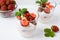 Fresh strawberries dessert layered with yogurt on white background