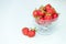 Fresh strawberries in glass bowl on white background