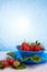 Fresh strawberries in mycelium on a wooden table in blue background