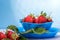 Fresh strawberries in mycelium on a wooden table in blue background