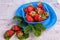 Fresh strawberries in mycelium on a wooden table in blue background