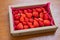 Fresh strawberries are neatly arranged and packed in cartons