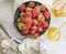Fresh strawberries on a plate, dessert honey, iris flower on a gray concrete background