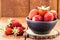 Fresh strawberries on rustic wooden background, in handmade clay bowl, space for text