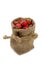 Fresh strawberries in a small hessian bag on a white background.