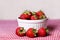 Fresh Strawberries in White Bowl on Red Gingham Tablecloth