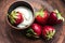 Fresh strawberry with whipping cream on a dark plate