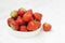 Fresh strawberry on white background in white bowl, fresh fruits for breakfast or healthy food snack, copy space