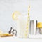 Fresh summer classic lemonade in glass with straw, ice, ingredients - lemons in silver bowl, shaker, slices fruit on board in soft