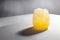 Fresh summer cold orange juice with ice in glass in sunlight with striped shadow on white table with gradient wall in modern.