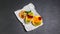 Fresh summer fruit with kiwi, orange and cherry on a shale board. toss sugar. top view, space for text