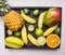 Fresh summer fruit mix, mini pineapple, mango, mini bananas, carambola, lime,quince in a wooden box, top view