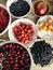 fresh summer fruits in ceramic bowls on wooden table in the kitchen.