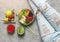 Fresh summer salad with quinoa, peach, micro greens, avocado, berries, melon on light background with smoothie, woman in jeans.