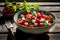 Fresh summer salad with strawberries, mozzarella and basil on wooden table