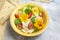 Fresh summer salad with vegetables and edible flowers nasturtium, borage flowers in a yellow bowl.