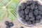 Fresh and sweet blackberry with leaves on the wooden background. Fresh and sunny fruit concept. Horizontal orientation.