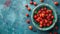 Fresh sweet cherries bowl with leaves in water drops on blue stone background, top view