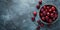 Fresh sweet cherries bowl with leaves in water drops on blue stone background, top view