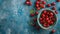 Fresh sweet cherries bowl with leaves in water drops on blue stone background, top view