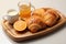 Fresh sweet croissants with orange jam on a wooden tray for breakfast