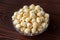 Fresh, sweet popcorn with caramel, golden color on the background of a dark wooden table, top view