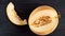 Fresh sweet yellow melon sliced on wooden black table. Piece of raw organic melon on wooden dark blurred background