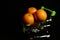 Fresh tangerines in a basket on a blurred black background