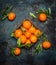 Fresh tangerines with leaves on dark grunge background