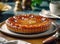 Fresh tarte tatin, upside down apple tart on black plate on wooden table, traditional french apple pie with caramelized apples.