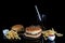 fresh tasty burger and french fries on black glass table with reflection