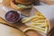 Fresh tasty burger and french fries on wooden table. french fries and bbq sauce on wood plate. street food burger and fried