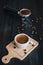 Fresh tasty espresso cup of hot coffee with coffee beans and Coffee maker on dark background