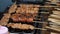 Fresh tasty meat on wooden skewers close up. Delicious grilled kebabs over the hot oil, slow motion