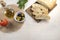 Fresh  tasty option for serving Italian focaccia. Sliced bread on serving board served with olives  tomatoes  olive oil and fresh