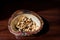 Fresh and tasty organic cashew nut trail mix in coconut shell bowl on wooden table.