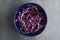 Fresh and tasty salad made with chopped red cabbage on the grey rustic table.Top view,minimal food preparation