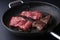 Fresh tenderloin steaks in frying pan. Bkack backfround