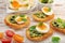 Fresh toasts with pesto and egg on wooden background