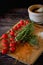 Fresh tomato cherry, green leaves of rosemary herbs, salt and  unprepared spaghetti on wooden board above view, background