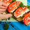 Fresh tomato and parsley, on roasted bread. Human hand take summer open sandwich. Can be used to demonstrate summer healthy