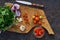 Fresh tomatoes, onion, garlic, parsley and chile on wooden board