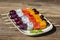 Fresh tropical fruit - grapes, mango, watermelon and pitahaya on skewers in white plate