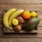 Fresh tropical fruits in a wooden box on a wooden background