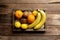 Fresh tropical fruits in a wooden box on a wooden background