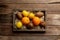 Fresh tropical fruits in a wooden box on a wooden background