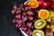 Fresh tropical fruitson in bowl on black marble background.