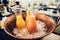 Fresh tropical orange and assorted juices in glass bottles on ice on bar counter in a cafe or restaurant.